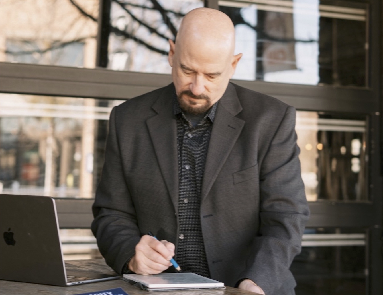 Mike Dennison writing notes on a tablet